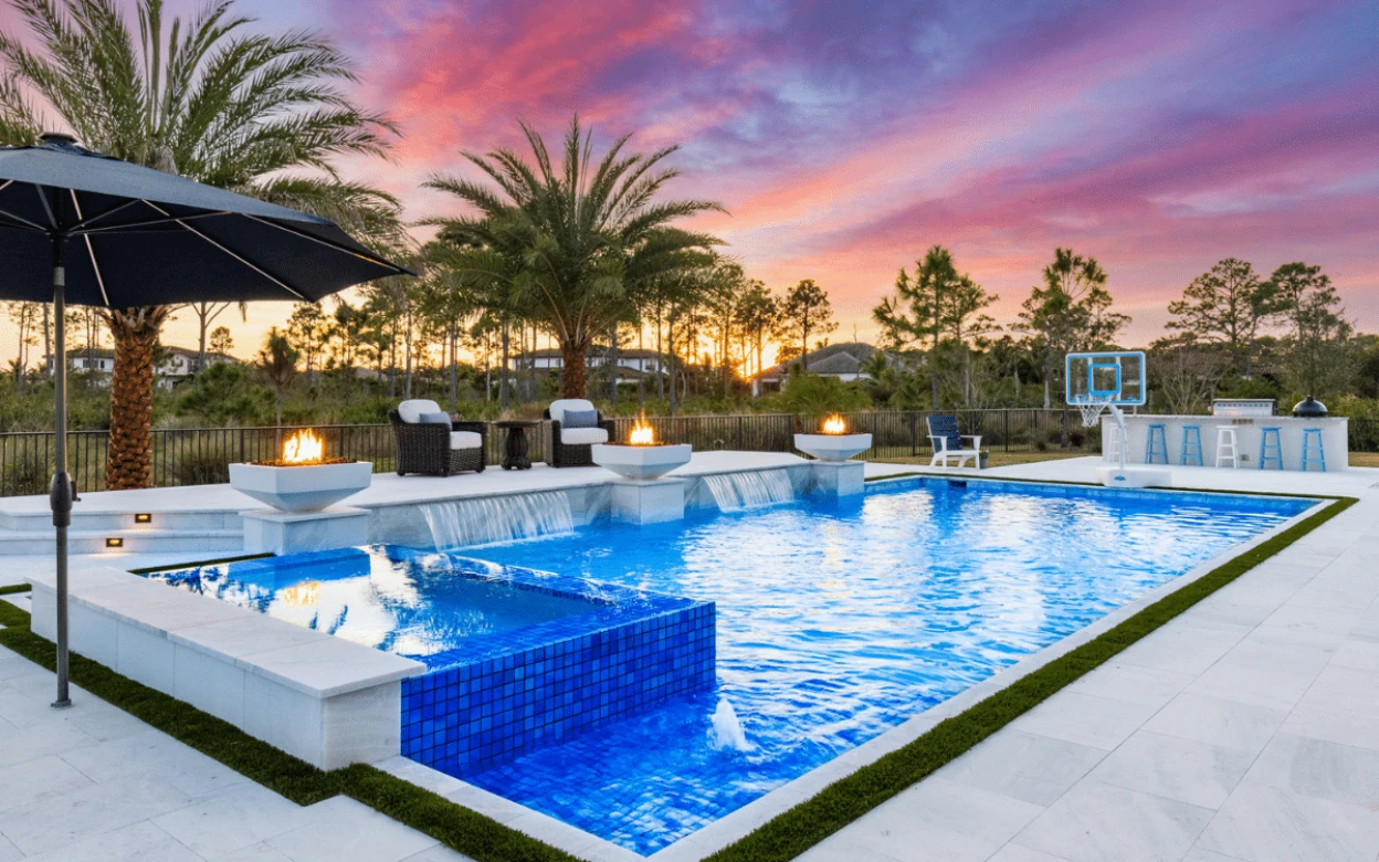 Fire bowls burning beside a custom pool at dusk